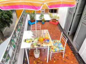 uma mesa e cadeiras numa varanda com um guarda-sol em Hostel Recanto de Alegrias em São Cristòvão no Rio de Janeiro