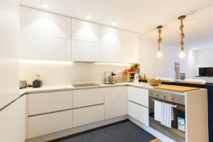 a white kitchen with white cabinets and a stove at Sweet Spot @ Alcântara in Lisbon