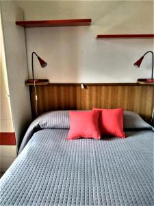 een slaapkamer met een bed met 2 rode kussens bij Appartamento Holiday cir 0050 in Saint Vincent