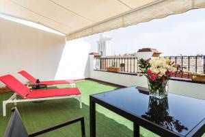 a balcony with a table and a vase of flowers at Hotel Sevilla in Seville