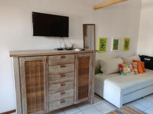 a living room with a couch and a flat screen tv at Stúdio 1 Armazém da Vila in Praia do Forte