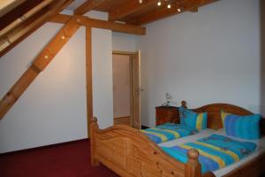una camera con letto in legno e cuscini blu di Ferienwohnungen DaHeim Titisee a Titisee-Neustadt