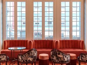 a living room with a couch and chairs and windows at Dear Lisbon - Valmor Palace in Lisbon