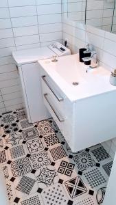 baño con lavabo blanco y suelo de baldosa blanco y negro en Soren-SUN Apt´s en Supetar