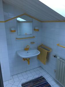 La salle de bains blanche est pourvue d'un lavabo et d'un miroir. dans l'établissement Ferienwohnung Meindl Elfi An der Drachenwand 44, à Mondsee