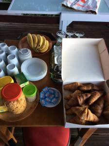 a table with a box of bread and other food at CHALET & MAISONS BULLES Deluxe in Bouillante