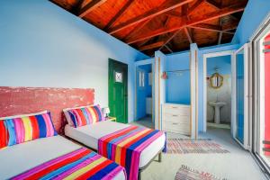 two beds in a room with blue walls at Art Studio Kefalonia in Dhavgáta