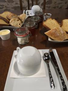 una mesa de madera con un plato de pan y una taza en La Rapiette de Noblat, en Saint-Léonard-de-Noblat 23 fotos más