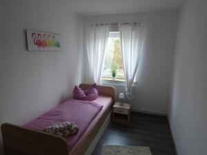 ヴィルヘルムスハーフェンにあるAn der Flut 269の小さなベッドルーム(紫色のベッド1台、窓付)