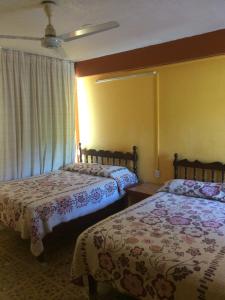 2 letti in una camera con pareti gialle di Hotel Olimar ad Acapulco Altre 37 foto