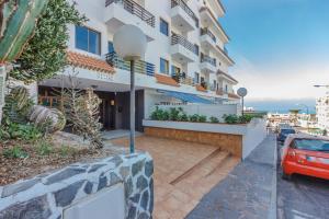 un edificio con un coche aparcado delante en Seguro Spacious apartment with roomy terrace, en Puerto de Santiago