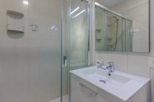 Un baño blanco con lavabo y ducha. en Seguro Spacious apartment with roomy terrace, en Puerto de Santiago 41 fotos más