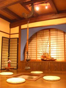 Habitación con alfombras, suelo de madera y ventanas en Minshuku Kuwataniya, en Takayama
