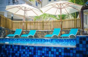 格蘭貝伊的住宿－Azur Paradise，一组椅子和遮阳伞,位于游泳池旁