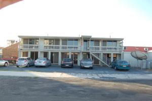 un gran edificio con coches estacionados en un estacionamiento en Slipway Hotel Motel, en Ballina