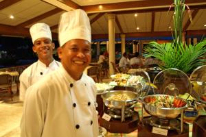 dos chefs parados frente a un buffet de comida en Almont Inland Resort, en Butuán