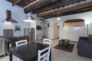 Il nido nascosto في لوكّا: مطبخ وغرفة معيشة مع طاولة سوداء وكراسي