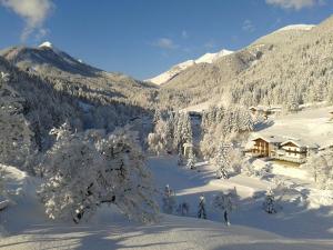 a ski lodge in the mountains with snow covered trees at Bio-Bauernhof "Hecherhof" in Thiersee