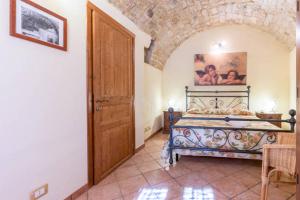 1 dormitorio con 1 cama y puerta de madera en Residenze San Paolo, en Ragusa