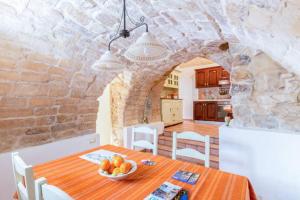 a kitchen and dining room with a table with a bowl of fruit at Residenze San Paolo in Ragusa