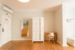 a room with a wooden floor and a white refrigerator at Lisboa Central Hostel in Lisbon