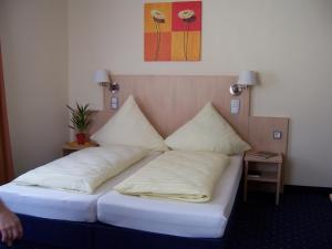 uma cama num quarto com duas almofadas em Landgasthof Hock em Großostheim