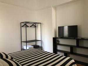 - une chambre avec un lit et une télévision dans l'établissement Antiguo departamento con excelente ubicación, à Buenos Aires