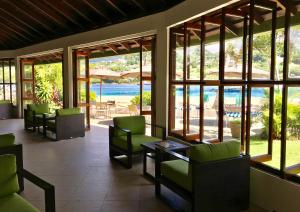 a lobby with chairs and a view of the water at Young Island Resort in Kingstown +37 photos