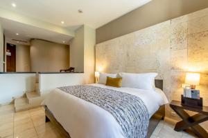 una camera con un grande letto e un muro di Hodelpa Nicolás de Ovando a Santo Domingo