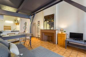 sala de estar con TV, mesa y piano en La fenêtre Saint jean en Lyon