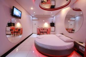 a bedroom with a large bed and a dining room at Euro Motel (Only Adults) in Viracopos