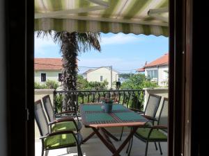 d'une terrasse avec une table et des chaises sur un balcon. dans l'établissement Apartments Eva, à Sukošan