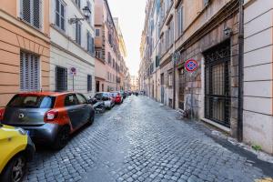 una calle con coches aparcados en una calle adoquinada en Colosseum Rione Monti 1, en Roma