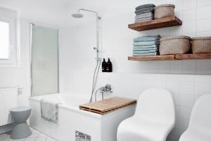 a white bathroom with a tub and a shower at Cityapartment Graz in Graz