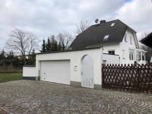 Maison blanche avec garage et clôture dans l'établissement Ferienwohnung Zur Trolle, à Erfurt