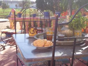 una mesa con un tazón de comida. en Les Tajines Bleus en Tamanar