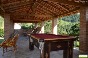 a pool table on a patio with a wooden roof at Pousada Trilha do Ouro Alagoa MG in Alagoa
