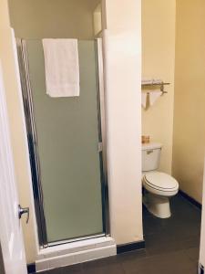 a bathroom with a toilet and a glass shower at Los Feliz Hotel in Glendale