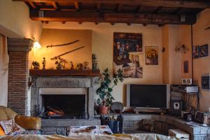 sala de estar con chimenea y TV en Villa Farfalla Bianca, en Vitorchiano
