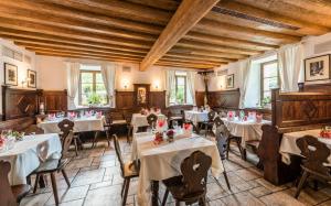 restauracja z białymi stołami, krzesłami i oknami w obiekcie Luxury Lodge - Orient Express Lener w mieście Freienfeld