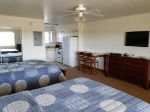 a bedroom with two beds and a kitchen with a tv at Shore Stay Suites in Cape Charles +5 photos