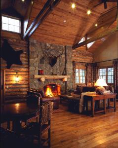 a living room with a fireplace in a log cabin at Circle Bar B Guest Ranch in Santa Barbara