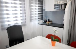a kitchen with a white table and red chairs at Work & Sleep in Piaseczno