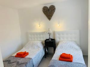 two beds in a room with a heart on the wall at Forever Views in Puerto del Carmen