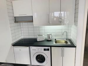 a kitchen with a washing machine and a sink at Forever Views in Puerto del Carmen