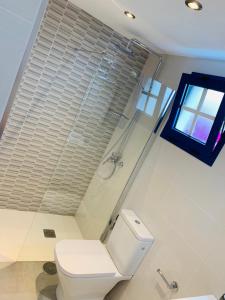 een badkamer met een wit toilet en een raam bij Forever Views in Puerto del Carmen +12 foto's