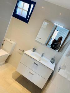 een vrouw die een foto neemt van een badkamer met een wastafel bij Forever Views in Puerto del Carmen