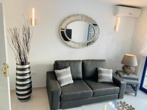 een woonkamer met een bank en een spiegel bij Forever Views in Puerto del Carmen