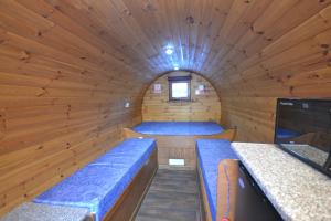 Habitación pequeña con bancos azules en una cabaña de madera. en Blackwater Glamping Pods, en Kinlochleven