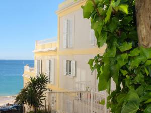 un edificio amarillo con el océano en el fondo en Casa Eugenia, en Sesimbra